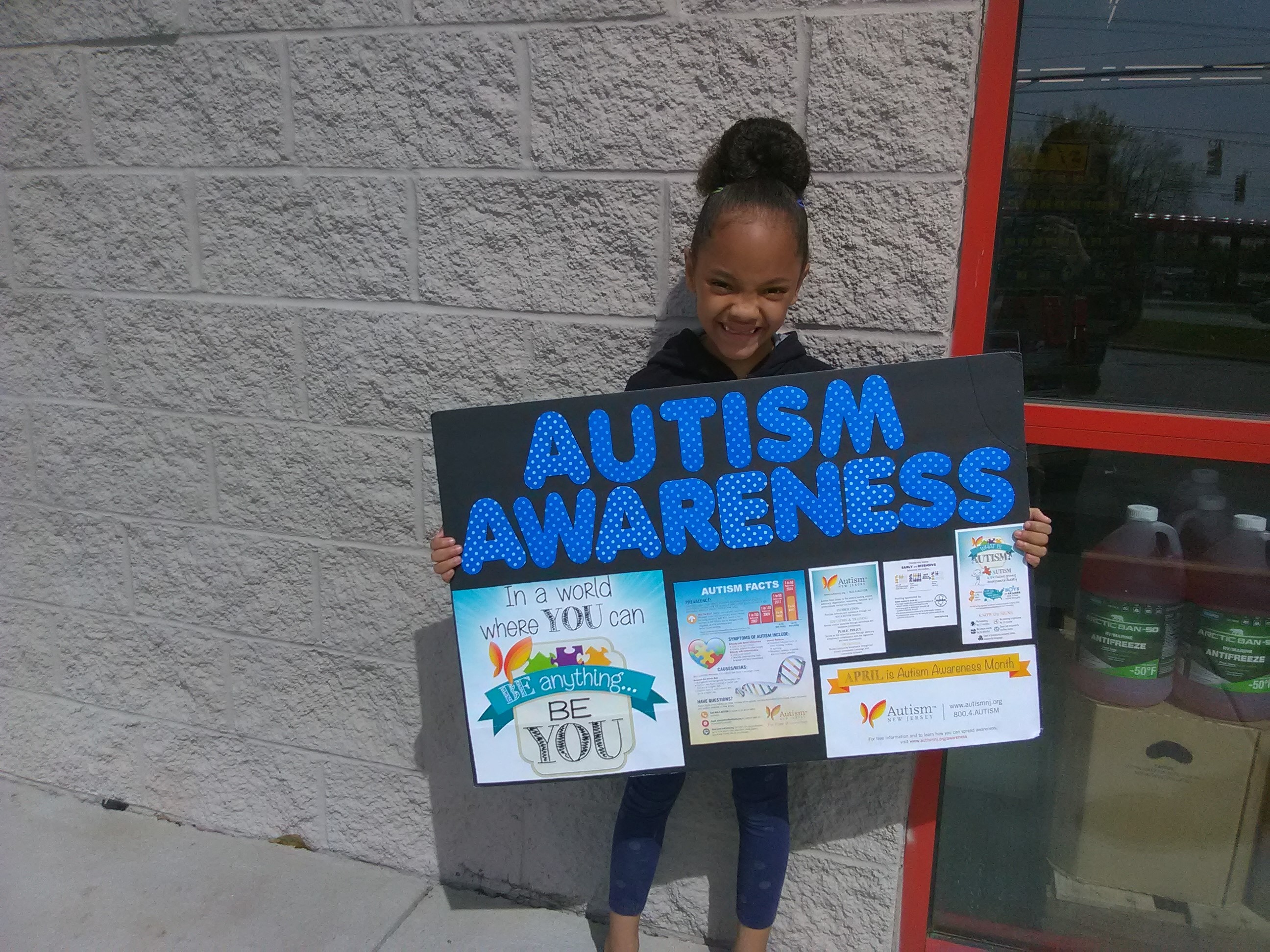 Girl holding Autism Awareness poster