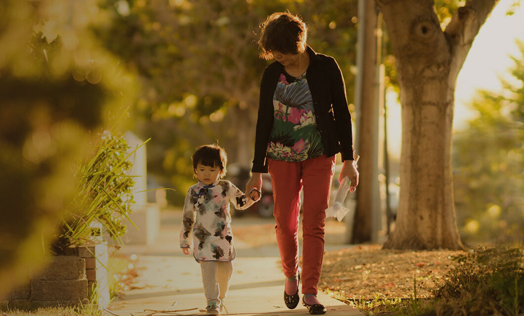 mother holding hands with young child