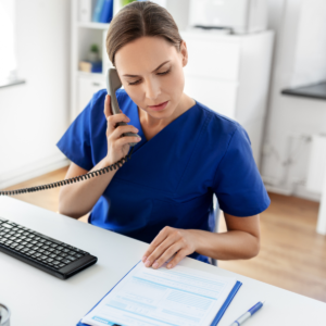 A nurse reviews a report while on the phone.